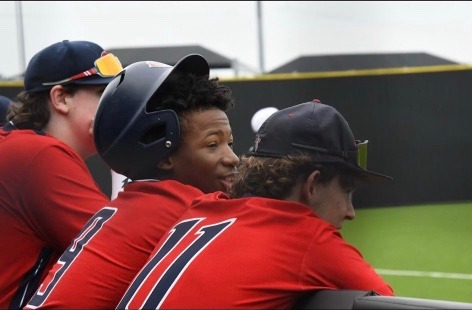 Karmelo Anthony with teammates in red baseball uniforms
