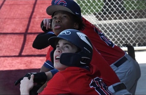 Karmelo Anthony laughing with teammate in baseball dugout